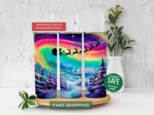 Three tumblers are showing all sides of a Merry Christmas Tumbler. Snowy scene with Northern Lights and Santa Reindeer with personalized name on the button of the tumbler.
