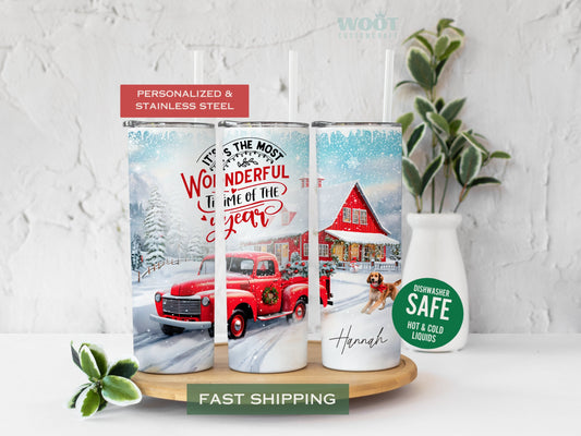Three tumblers are showing all sides of a Merry Christmas Tumbler. A snowy scene with a red truck carrying a Christmas tree on the back, and a dog running. A text that says It is the most wonderful time of the year and the personalized name.