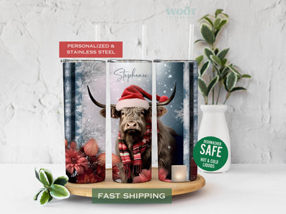 Three tumblers are showing all sides of a Christmas Highland Cow Tumbler. It is snowing. There is a cow and flowers, snow, and a personalized name.