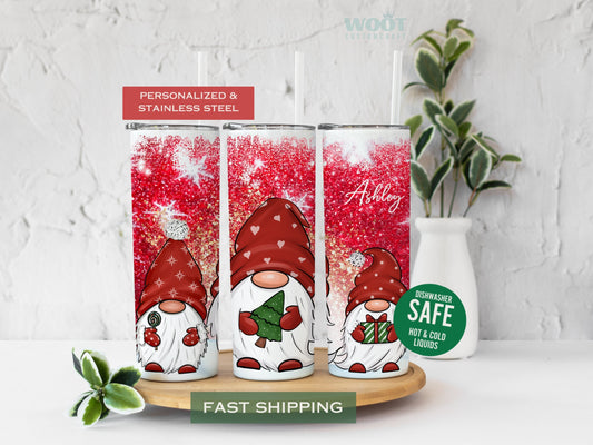 Three tumblers are showing all sides of a Merry Christmas Tumbler. Snowy scene with Snowflakes. Three gnomes and the personalized name in the top of the tumbler.