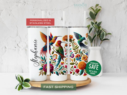 Three tumblers show all sides of a Hummingbird Tumbler Personalized. There are flowers and a personalized name.