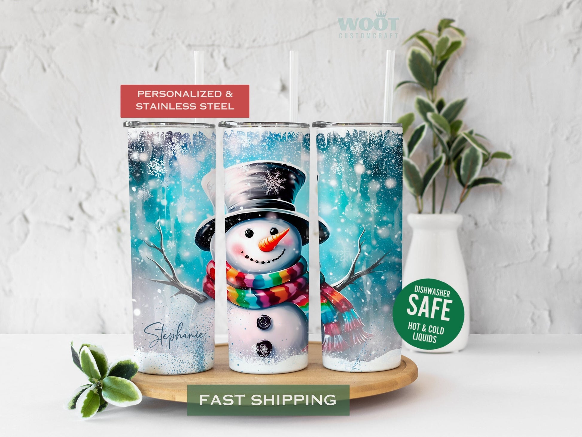 Three tumblers are showing all sides of a Christmas Winter Tumbler. A snowy scene with a blue background. A Snowman in the center, some Christmas trees, and a personalized name on the button of the tumbler.