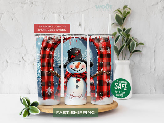 Three tumblers are showing all sides of a Christmas Winter Tumbler. A snowy scene with a Snowman in the center, some Christmas trees, and a personalized name on the button of the tumbler.