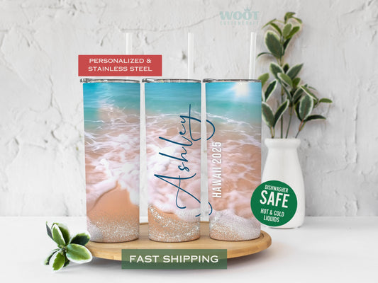 Three tumblers display various sides of a personalized beach vacation tumbler. There is a beach with waves on the sand, glitter, and details such as the name and year of the visited beach.